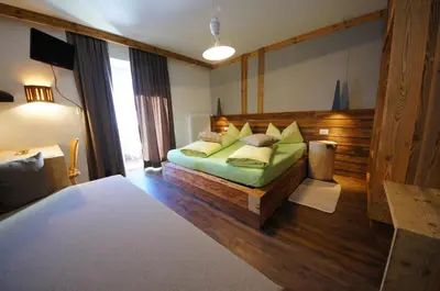 a bedroom with a bed with green sheets and pillows at Appartamenti Residence Pars in Badia