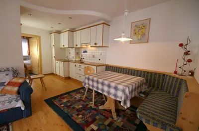 a living room with a couch and a table and a kitchen at Appartamenti Residence Pars in Badia