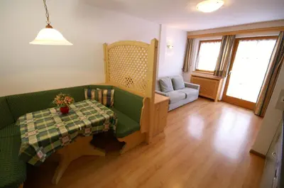 a living room with a green couch and a table at Appartamenti Residence Pars in Badia