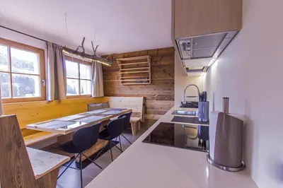 a kitchen with a table and chairs in a room at Appartamenti Residence Pars in Badia