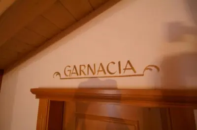 a sign on a wall above a wooden door at Appartamenti La Munt in Badia