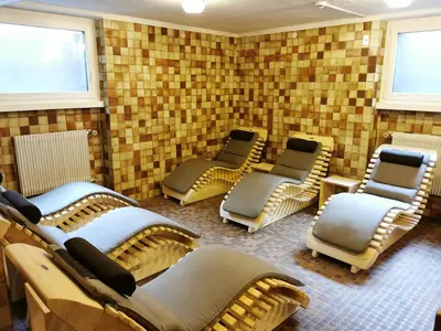 a waiting room with chairs in a room with brick walls at Hotel la Plaza in Corvara in Badia