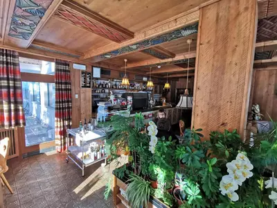 a restaurant with plants in the middle of a room at Hotel la Plaza in Corvara in Badia