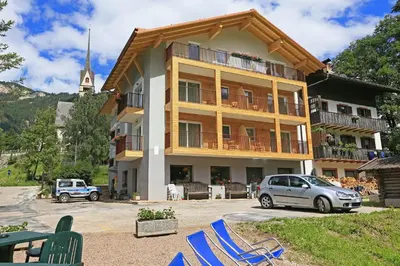 a building with a car parked in front of it at Hotel San Giovanni in Vigo di Fassa