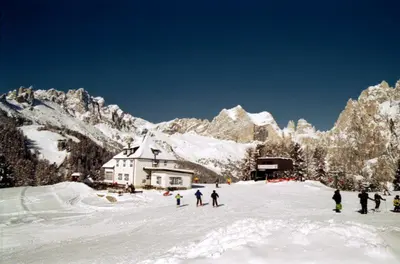 a group of people standing in the snow in front of a building at Hotel San Giovanni in Vigo di Fassa