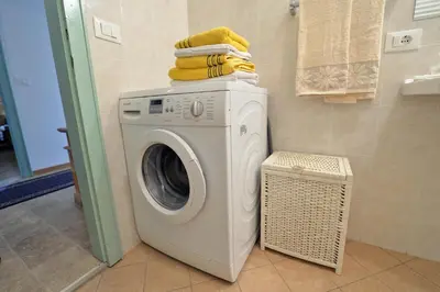 a washing machine with towels on top of it in a bathroom at Apartments Dolomie in Ortisei