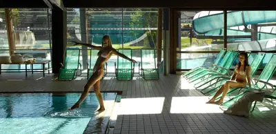 two woman in bathing suits standing in a swimming pool at Apartments Dolomie in Ortisei