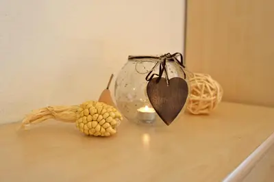 a table with a candle and a vase with a heart at Apartments Dolomie in Ortisei