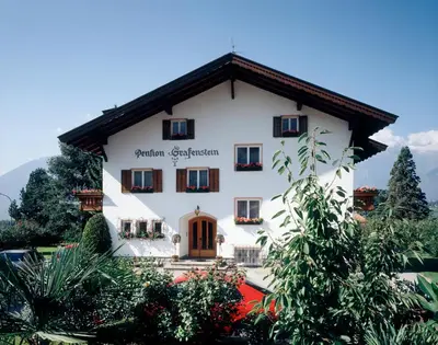 a large white building with trees in front of it at Guesthouse Pension Grafenstein in Merano
