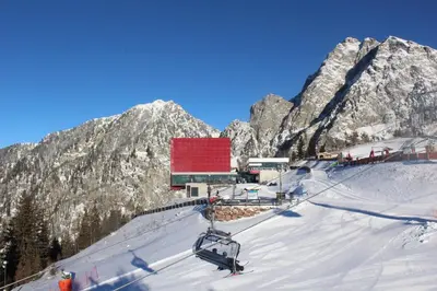 a ski lift with a red roof on a snowy mountain at Guesthouse Pension Grafenstein in Merano