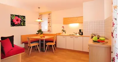 a kitchen and dining room with a table and a kitchen and a room at Stocknerhof in Bressanone