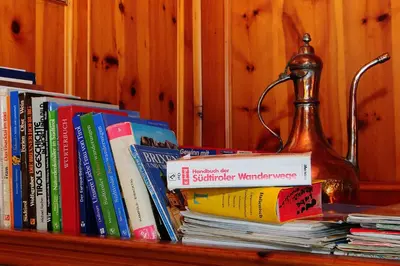 a pile of books sitting on a book shelf at Stocknerhof in Bressanone