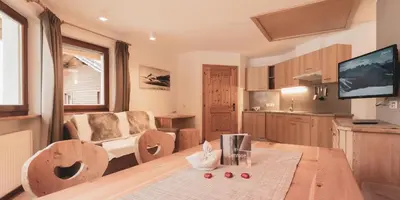 a kitchen and living room with a table and a couch at Residence Alpenrose in Bressanone