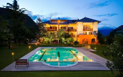 a villa with a swimming pool in front of a house at Hotel Weingut Klosterhof in Caldaro