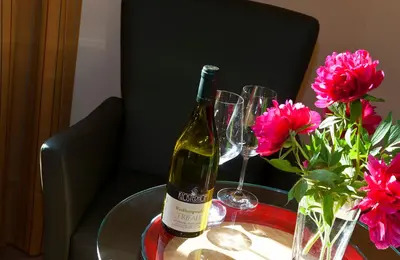 a bottle of wine sitting on a table with two glasses at Hotel Weingut Klosterhof in Caldaro