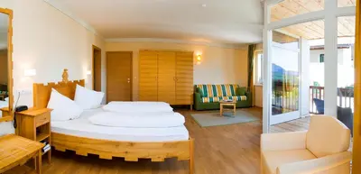 a bedroom with a white bed and a balcony at Hotel Weingut Klosterhof in Caldaro