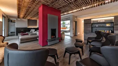 a bar with chairs and a fireplace in a room at Hotel Weingut Klosterhof in Caldaro