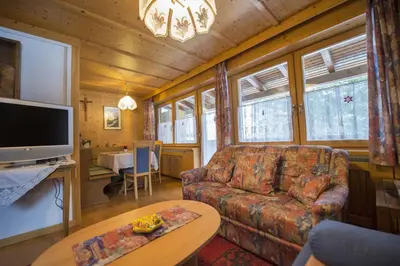 a living room with a couch and a tv and a table at Apartment Soval in Ortisei