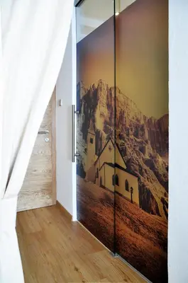 a bathroom with a shower with wooden walls at Guesthouse Rungg in Badia