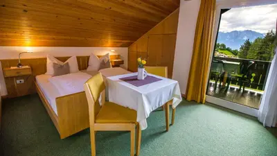 a bedroom with a bed and a table and a window at Appartments Neuhof in Collalbo