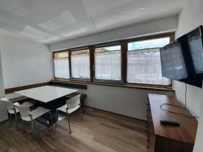 a dining room with a table and some windows at Ciasa De Rosa in Pozza di Fassa