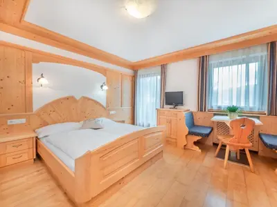 a bedroom with a bed and a desk and a computer at Ciasa Raut in La Valle