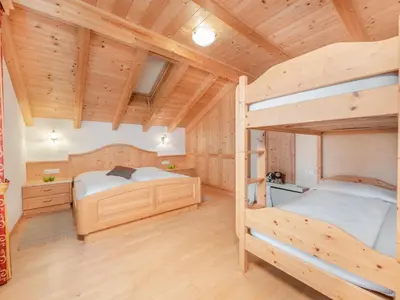 two bunk beds in a room with wooden ceilings at Ciasa Raut in La Valle