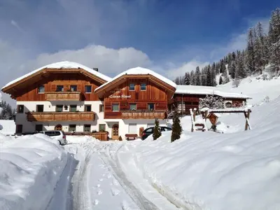 a ski lodge in the snow with a road in front at Ciasa Raut in La Valle