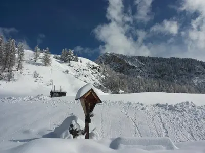 a snow covered slope with a mountain in the background at Ciasa Raut in La Valle