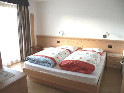 a bedroom with a bed with four pillows on it at Ciasa Isidor in San Vigilio Di Marebbe