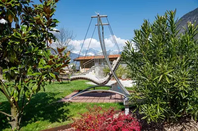 a swing in the middle of a garden at Hotel Neuhausmühle in Vilpiano
