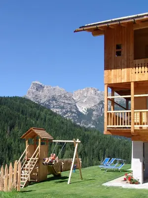 a person sitting in a hammock on a playground at Apartments Serghela in San Cassiano