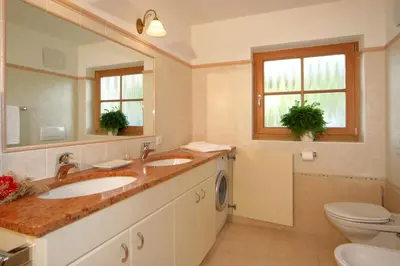 a bathroom with two sinks and a toilet at Apartments Serghela in San Cassiano