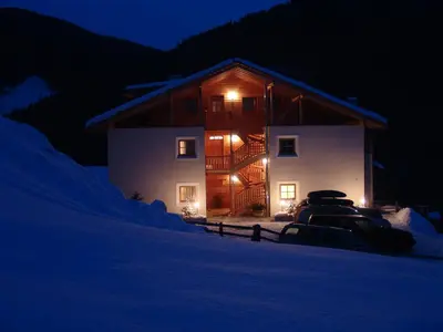 a house with a car parked in front of it at night at Apartments Serghela in San Cassiano