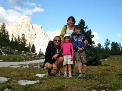 a family posing for a picture in front of a mountain at Apartments Serghela in San Cassiano