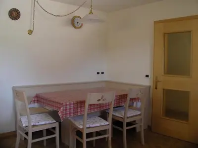 a dining room table with two chairs and a table with a tablecloth at Appartamenti Suttru in Badia