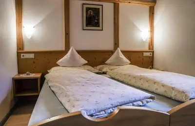 two twin beds in a room with a mirror at Aria D'Bosch in Badia