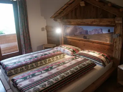 two beds in a bedroom with a wooden headboard at Aria D'Bosch in Badia