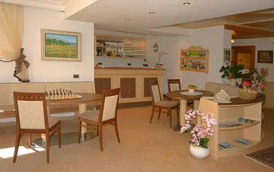a kitchen and dining room with a table and chairs at Garni Hotel Rezia in Selva di Val Gardena