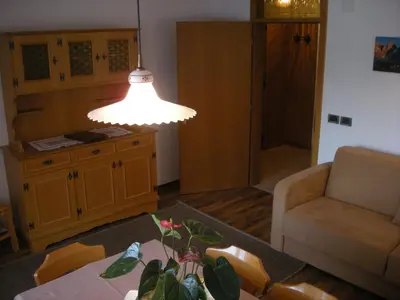 a living room with a table and a light at Garni Hotel Rezia in Selva di Val Gardena