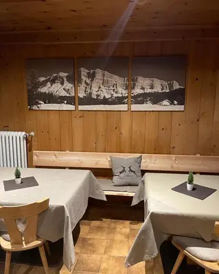 a room with two beds and two tables at Lamirì in Badia