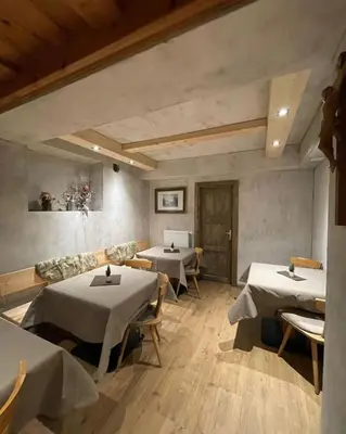 a dining room with two tables and a couch at Lamirì in Badia