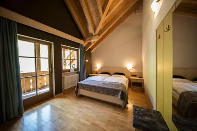 a bedroom with two beds and a large window at Aria d' Prè in Badia
