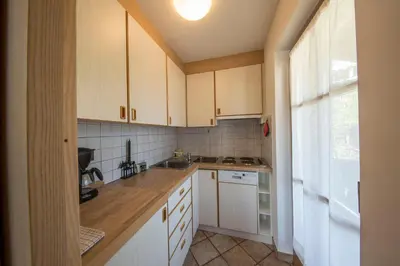 a small kitchen with white cabinets and a window at Aria d' Prè in Badia