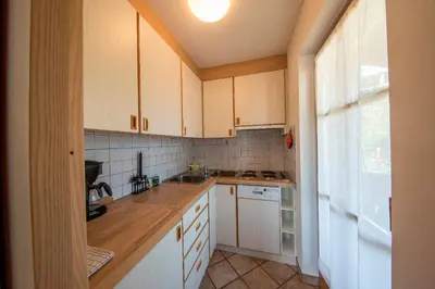a small kitchen with white cabinets and a window at Aria d' Prè in Badia