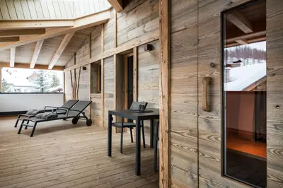 a kitchen and living room with a table and chairs at Les Contrades in La Villa
