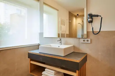 a bathroom with a white sink and a window at Les Contrades in La Villa
