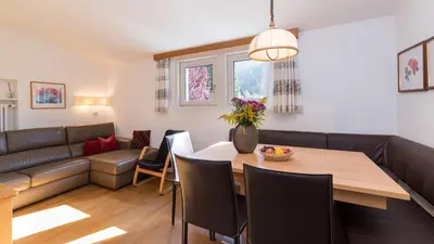 a living room with a table and a couch at AppartChalet LA RONDULA - 100m from Seceda in Ortisei