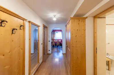 a hallway with wooden doors and a dining room at Residence Bosco Verde in San Cassiano
