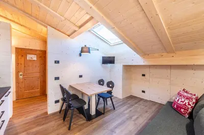 a room with a wooden table and chairs at Residence Bosco Verde in San Cassiano